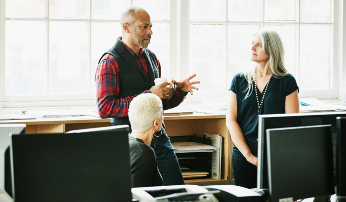 Three business people in discussion.