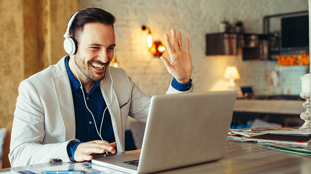 Businessman waving to participants on a virtual call.