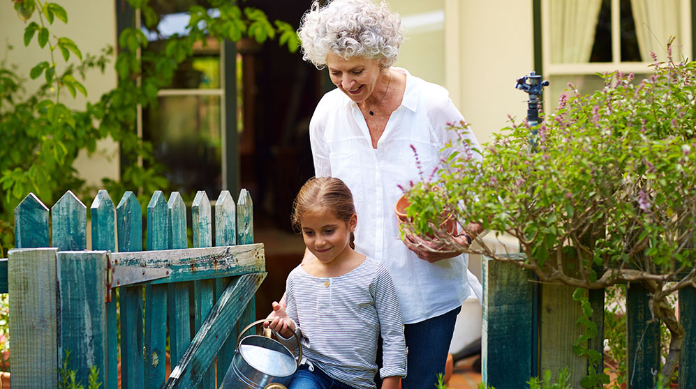 Older woman gardening with granddaughter