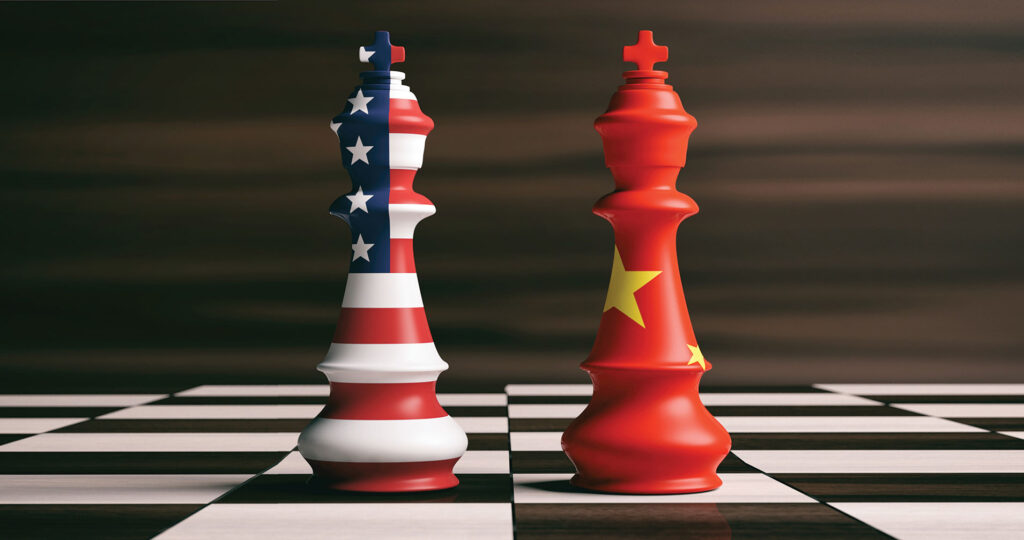 Two king chess pieces on a chess board, one colored in U.S. flag and one colored in China flag.