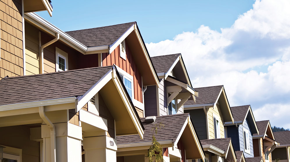 Lined of peaked townhome roofs.