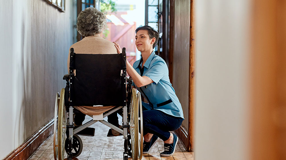 person in wheelchair being helped by a nurse