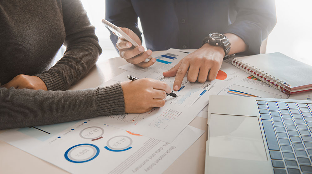 people looking at wealth management graphs and reports